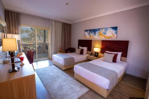 a hotel room with two beds and a balcony at Stella Beach Resort & Spa Makadi Bay - 24 HRS All Inclusive in Hurghada