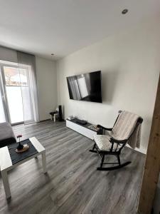 a living room with a chair and a television on a wall at Apartment Lindenstein in Fritzlar