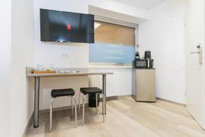 a kitchen with a table and two stools at Private room #5 with 2 twin beds, ground floor, AC, only 2min to RAB, no kitchen in Ramstein-Miesenbach