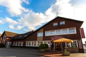 a building with an umbrella in front of it at Hotel Restaurant Brinckwirth in Ochtrup