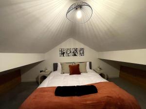 a bedroom with a large white bed with a ceiling at Central Industrial Chic 2-Bedroom Flat in Crewe