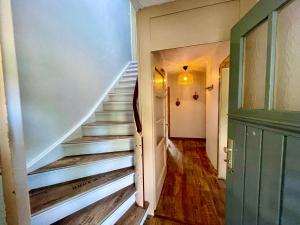einen Flur mit Treppe in einem Haus mit grüner Tür in der Unterkunft HIRSCH Gretel Ferienhaus - Garten mit Grill - Wald in Altenau