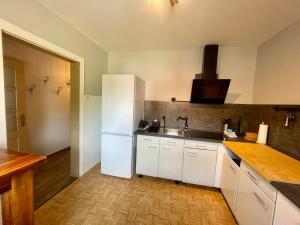 eine Küche mit einem weißen Kühlschrank und einer Spüle in der Unterkunft HIRSCH Gretel Ferienhaus - Garten mit Grill - Wald in Altenau + 24 Fotos