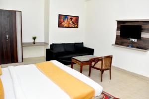 a bedroom with a bed and a couch and a table at Hotel P S Villa & Banquet in Agra