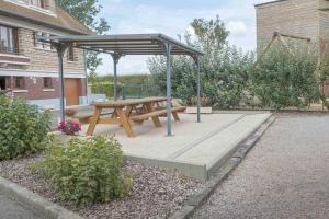 a picnic table with a canopy in a garden at Villa des champs in Villers-sous-Foucarmont