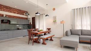 a kitchen and dining room with a table and a couch at Capricorn by The StayCationer in Dehradun