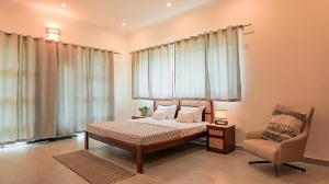 a bedroom with a bed and a chair at Capricorn by The StayCationer in Dehradun