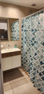 a bathroom with a shower curtain and a sink at Quequen - Vista al Mar in Quequén