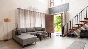 a living room with a couch and a table at Capricorn by The StayCationer in Dehradun