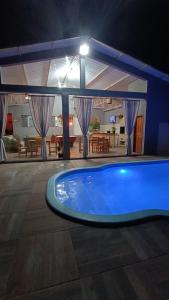 a swimming pool in a house at night at Pousada Água Doce - Porto Eucalipto in Pôrto São José