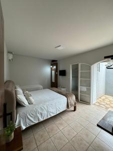 a bedroom with a bed and a television in it at Pousada Água Doce - Porto Eucalipto in Pôrto São José +19 photos