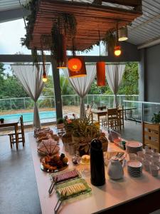 a dining room with a table with food on it at Pousada Água Doce - Porto Eucalipto in Pôrto São José