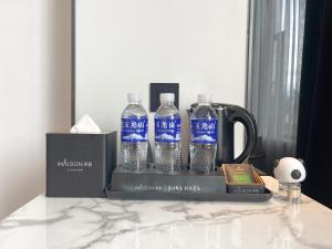 丽江Lijiang MΛISON Hotel的桌子上三瓶水