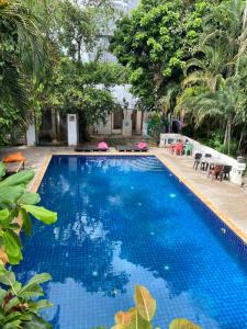 Una gran piscina azul con árboles al fondo. en Namton Boutique Hotel, en Chiang Mai