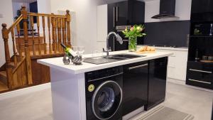 a kitchen with a washing machine and a sink at St Hildas Complex in Hinderwell