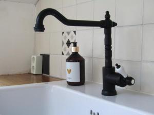 a bottle of soap sitting on top of a bath tub at Boerderijhuisje 22 - Landelijk logeren bij Sneek in Loënga +29 photos