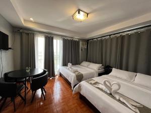 タガイタイにあるRangya Hotelのベッド2台とテーブルがあるホテルの部屋 +82枚の写真