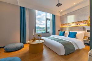 丽江Lijiang MΛISON Hotel的一间带大床和大窗户的卧室