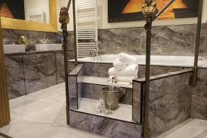 a bathroom with a tub and a sink and towels at St Hildas Complex in Hinderwell