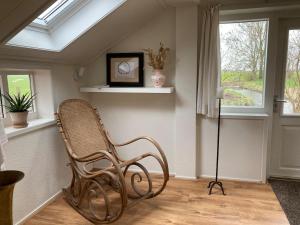 a wicker chair in a room with a window at Boerderijhuisje 22 - Landelijk logeren bij Sneek in Loënga