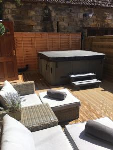 a hot tub sitting on a deck with two couches at St Hildas Complex in Hinderwell