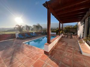 a patio with a swimming pool and a house at Villa Ana in Alhaurín el Grande