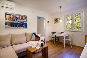 a living room with a couch and a table at 150m to Beach - Free Parking - Garden View in Slano