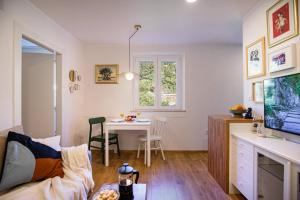 a living room with a table and a dining room at 150m to Beach - Free Parking - Garden View in Slano
