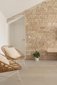 a room with a rattan chair and a brick wall at A Casiña in Nigrán