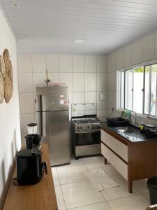 a kitchen with a stainless steel refrigerator and a stove at Casa paraíso dos milagres in São Miguel dos Milagres +18 photos