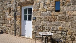 a table and two chairs in front of a stone building at St Hildas Complex in Hinderwell
