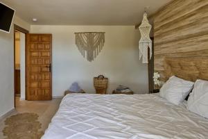 a bedroom with a large white bed with a wooden headboard at Casa El Sueño in Jávea