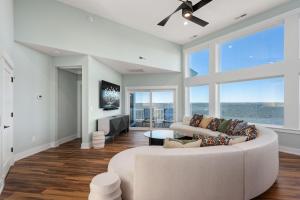 a living room with a white couch and large windows at NH599 Nags Head 599 in Nags Head