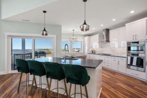 a kitchen with a large island with green bar stools at NH599 Nags Head 599 in Nags Head