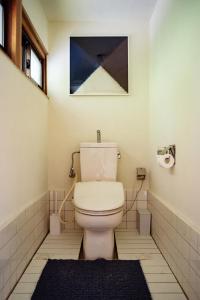 a bathroom with a toilet and a painting on the wall at 網ノ屋 - Aminoya Beach House Ezura in Shirahama