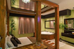 um quarto com uma cama, uma banheira e uma pia em Motel Hotel Paradiso - Passo Fundo-RS em Passo Fundo