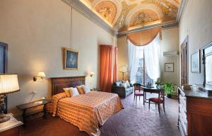a bedroom with a bed and a desk in a room at Hotel Palazzo Guadagni in Florence