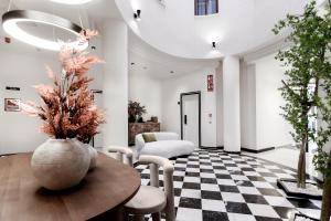 a living room with a table and chairs at Hotel Aptos Alejandra Homes by Maxi Hoteles in Granada