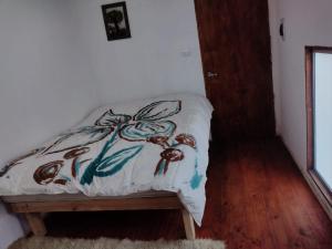 a bed in a room with a pillow on it at proteas departamento interior in Pichilemu