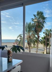 okno z widokiem na plażę i palmy w obiekcie Motril, primera línea de playa. w mieście Motril