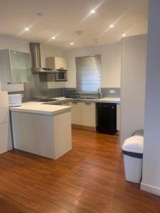 a kitchen with white appliances and a wooden floor at Spacious Central Penthouse Apartment With Parking in Manchester