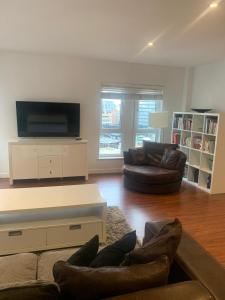 a living room with two couches and a flat screen tv at Spacious Central Penthouse Apartment With Parking in Manchester
