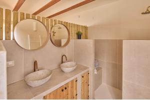 two sinks in a bathroom with two mirrors at Casa El Sueño in Jávea
