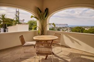 a table and chairs on a balcony with a view at Casa El Sueño in Jávea