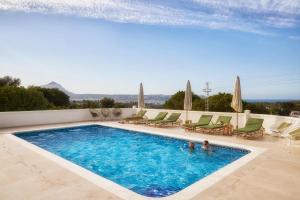 a swimming pool with chaise lounge chairs and a pool at Casa El Sueño in Jávea