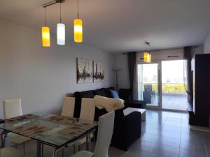 a dining room and living room with a table and chairs at Lujoso apartamento con vistas al mar R61 by Novadesta in Puerto Marino