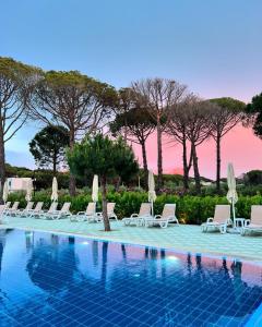 a swimming pool with lounge chairs and umbrellas at Lavender Beach House in Draç