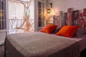 a bedroom with a bed with two orange pillows at TI'BAKOUA in Les Anses-dʼArlets