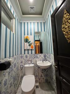 a bathroom with a toilet and a sink at El Villa Forest Bogor in Bogor