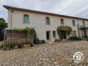 a house with a stone driveway in front of it at Domaine de Stony - Eco-Gîtes et Vignoble in La Peyrade